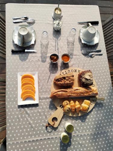 een tafel met een ontbijt van brood en eten erop bij Chambre d'hôte ensoleillée à 300m de la plage in La Guérinière
