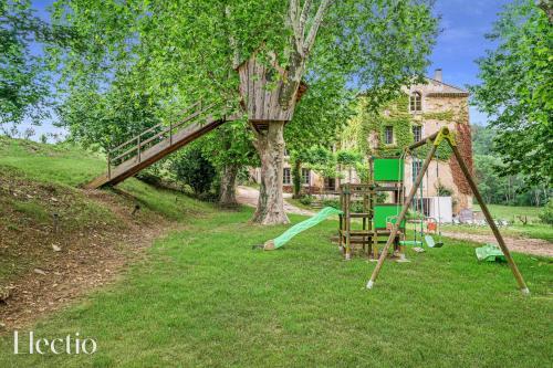 a playground with a tree and a swing at Parenthèse en Luberon in Rustrel