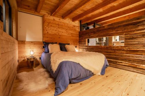 1 dormitorio con 1 cama en una cabaña de madera en Chalet Beleza en La Salle Les Alpes