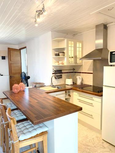 une cuisine avec une table en bois et un réfrigérateur blanc dans l'établissement Coeur de Lorgues, à Lorgues