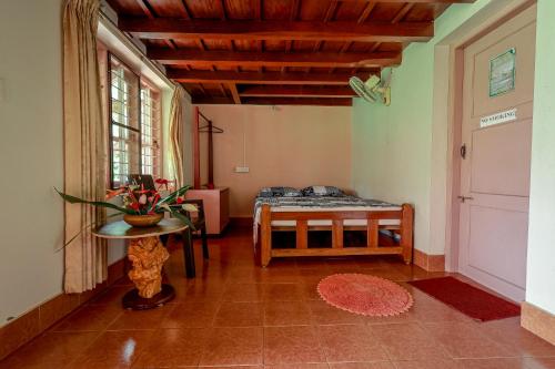 a room with a bed and a table and a window at Prakruthi Home Stay in Sollebail