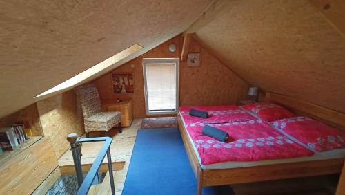 een slaapkamer met een rood bed op zolder bij Doudleby u Českých Budějovic in Doudleby