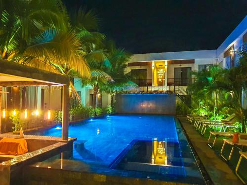 a swimming pool in front of a house at night at Central Corner Suite in Siem Reap