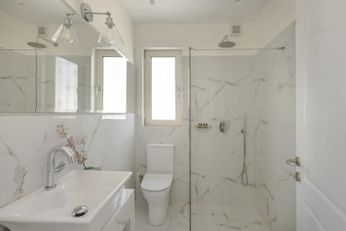 スヴォロナータにあるThe Seasonsの白いバスルーム(トイレ、シャワー付)