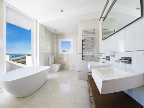 a white bathroom with two sinks and a large window at REf 6 VILLA TARA in Zahara de los Atunes