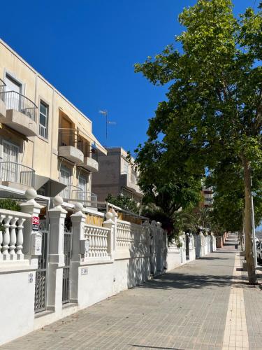 eine Straße mit einem Baum und einem Gebäude in der Unterkunft Sol Apartment in Arenales del Sol