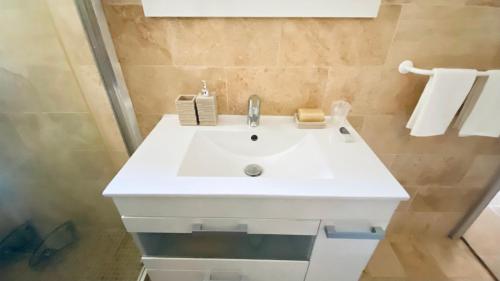 La salle de bains est pourvue d'un lavabo blanc. dans l'établissement Appartement T2 - Saint-Blaise - Moderne, à Bollène