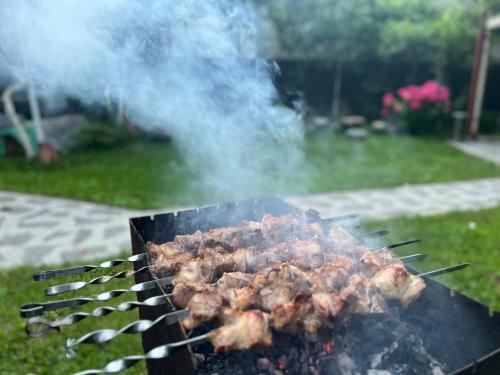 een grill met vlees erop in een tuin bij Home Inn-Guesthouse in Lagodekhi