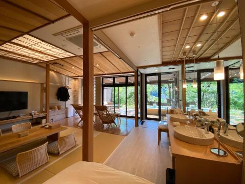 a bathroom with a sink and a living room at Kaiseki Ryokan Ashikari in Yugawara
