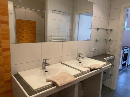ein Badezimmer mit zwei Waschbecken und einem großen Spiegel in der Unterkunft Deluxe Apartment DONNA in Schladming