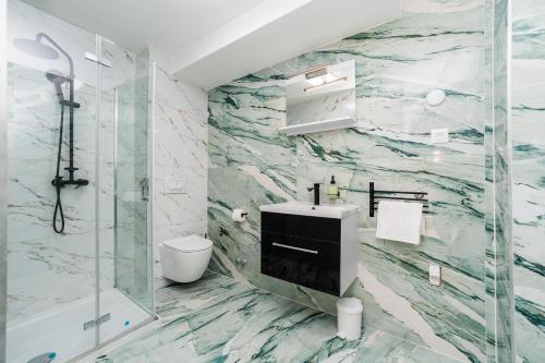 La salle de bains est pourvue d'un lavabo et d'une douche. dans l'établissement Holiday House Dominik apartments, à Sveti Petar