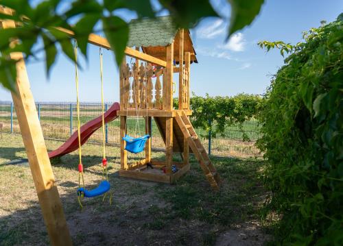 a playground with a slide and swings at Portita spre Delta in Jurilovca