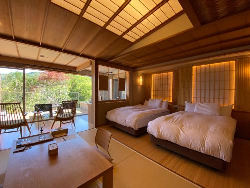 湯河原的住宿－阿施卡里懷石日式旅館，一间卧室配有两张床和一张桌子及椅子