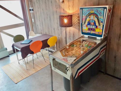 Le Relais des Fagnes في Sart-lez-Spa: لعبة pinkall في غرفة مع طاولة وكراسي