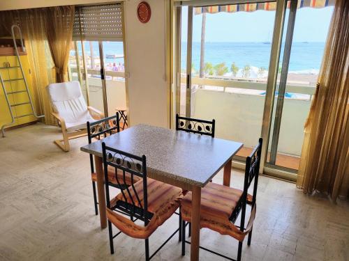 a dining room with a table and chairs and the ocean at Marimar in Antibes