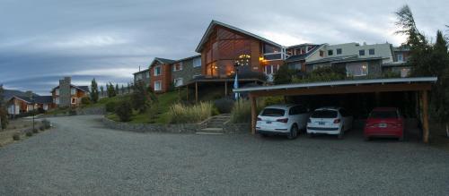 a car parked on the side of a road next to a house at Blanca Patagonia Hostería Boutique y Cabañas in El Calafate