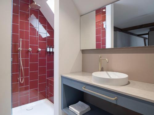 a bathroom with a sink and a shower with red tiles at Villa Helvetia in Merano