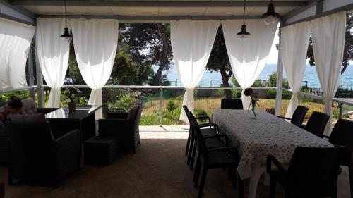 a restaurant with a table and chairs and a large window at Beach House Wild Paradise in Silba