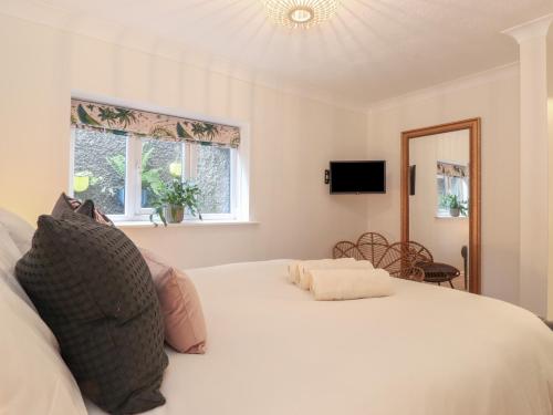 um quarto com uma grande cama branca e uma janela em The Sunflower em Windermere