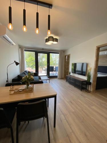 sala de estar con mesa y sofá en Szemespart Residence Apartmanok By BLTN, en Balatonszemes