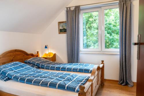 two beds in a bedroom with a window at Domki Letniskowe in Grzybowo