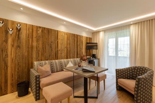 a living room with a couch and a table at Hotel Garni Jagdhof in Zell am Ziller