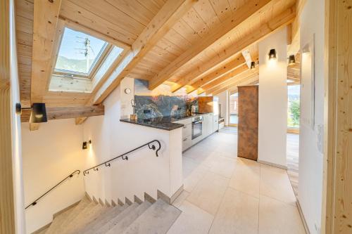 a kitchen with wooden ceilings and a skylight at Ferienwohnungen Zum Bachl - Karwendelblick in Krün
