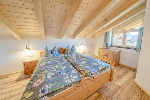 a bedroom with a large wooden bed with blue pillows at Ferienwohnungen Zum Bachl - Karwendelblick in Krün