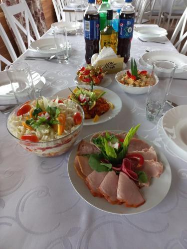 a white table with plates of food on it at Dom Piotra in Goniadz