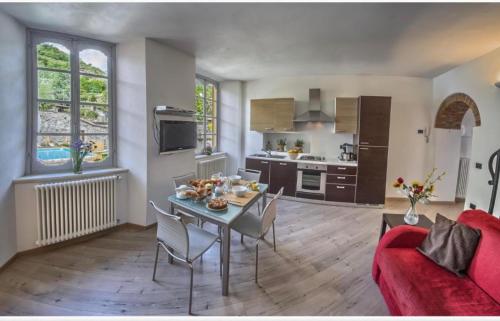 a kitchen and living room with a table and chairs at VILLA VINICIA, pool, jacuzzi, airco in Domaso