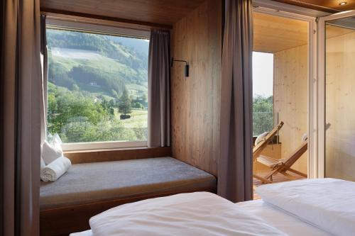 a bedroom with a window with a view of a mountain at Alpine Life Hotel Anabel in Cadipietra