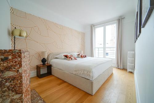 Un dormitorio con una cama y una ventana grande. en Apartment next to Palais des Congrès - Neuilly, en Neuilly-sur-Seine