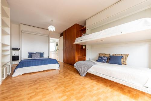 zwei Betten in einem Schlafzimmer mit Holzboden in der Unterkunft Luminoso Bungalow con parking in Tarragona