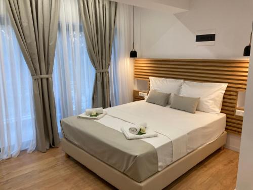 a bedroom with a large white bed with two plates on it at Ampoulos Rooms & Apartments in Kedro