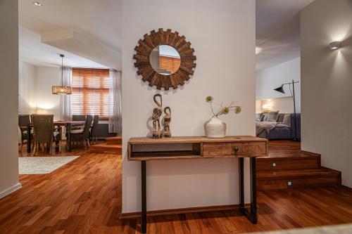 a living room with a table and a mirror at STING Boutique Apartments in Ostrava