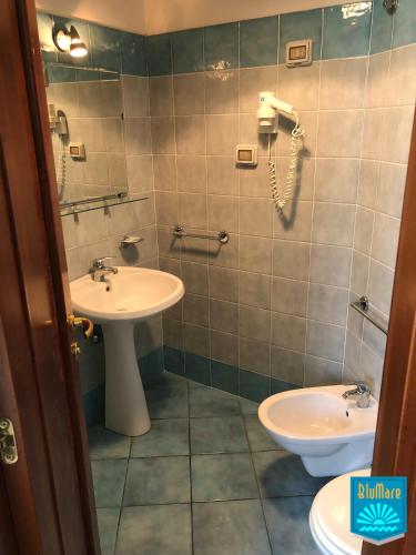 a bathroom with a sink and a toilet and a phone at Blu Mare in Ponza
