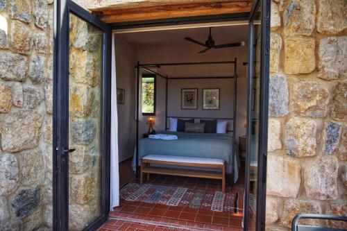 a bedroom with a bed in a stone wall at Bkerzay in Baakleen
