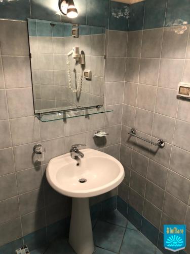 a bathroom with a sink and a mirror and a phone at Blu Mare in Ponza