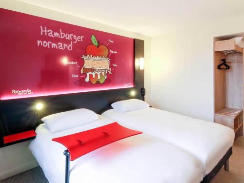 two beds in a hotel room with at ibis Styles Flers in Flers