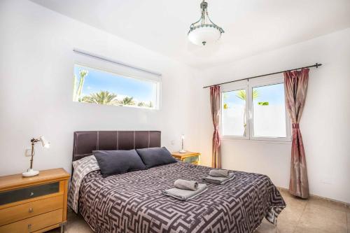 a bedroom with a bed and a window at Villa Tian in Puerto Calero
