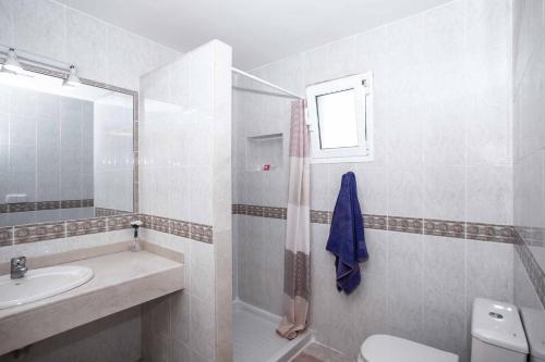 a white bathroom with a sink and a toilet at Villa Tian in Puerto Calero