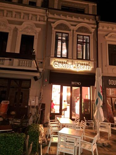 un ristorante con tavoli e sedie di fronte a un edificio di Bistro Centru Vechi Craiova a Craiova