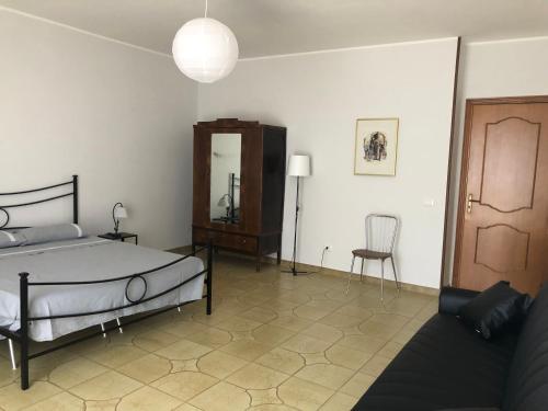 a bedroom with a bed and a chair and a mirror at The reed in Mazzarino