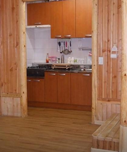 a kitchen with wooden cabinets and a stove top oven at Yeongwol Healing Forest Pension in Yeongwol