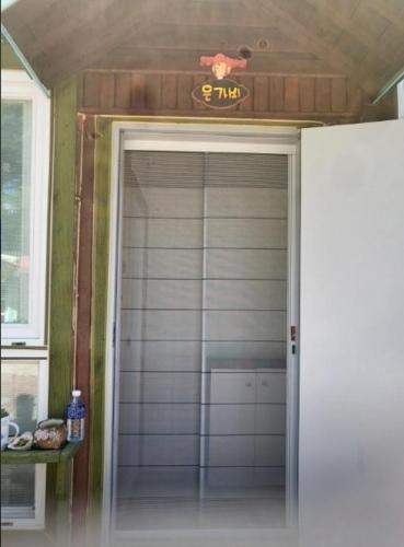 Una puerta con un reloj encima. en Yeongwol Healing Forest Pension, en Yeongwol