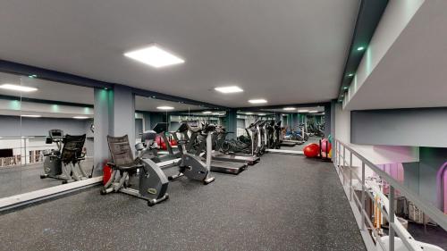 a gym with several treadmills and cardio machines at Acrotel Athena Residence in Elia