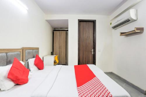 - une chambre avec un lit blanc et des oreillers rouges dans l'établissement OYO Flagship 77674 Hotel White Inn, à New Delhi