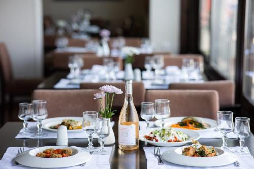 a table with plates of food and a bottle of wine at Portaria Hotel in Portariá