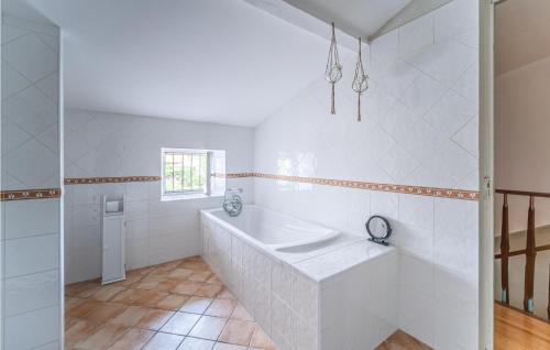 Baño blanco con bañera y lavamanos en Beautiful Home In Villegly With Kitchen, en Villegly