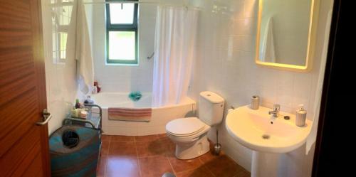 uma casa de banho com um WC, um lavatório e uma banheira em Los Robles-PLAYA COROSO em Ribeira